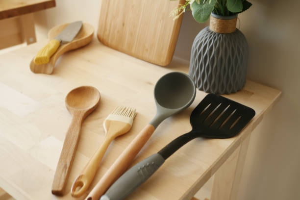 Wooden and silicone kitchen utensils arranged on a wooden table