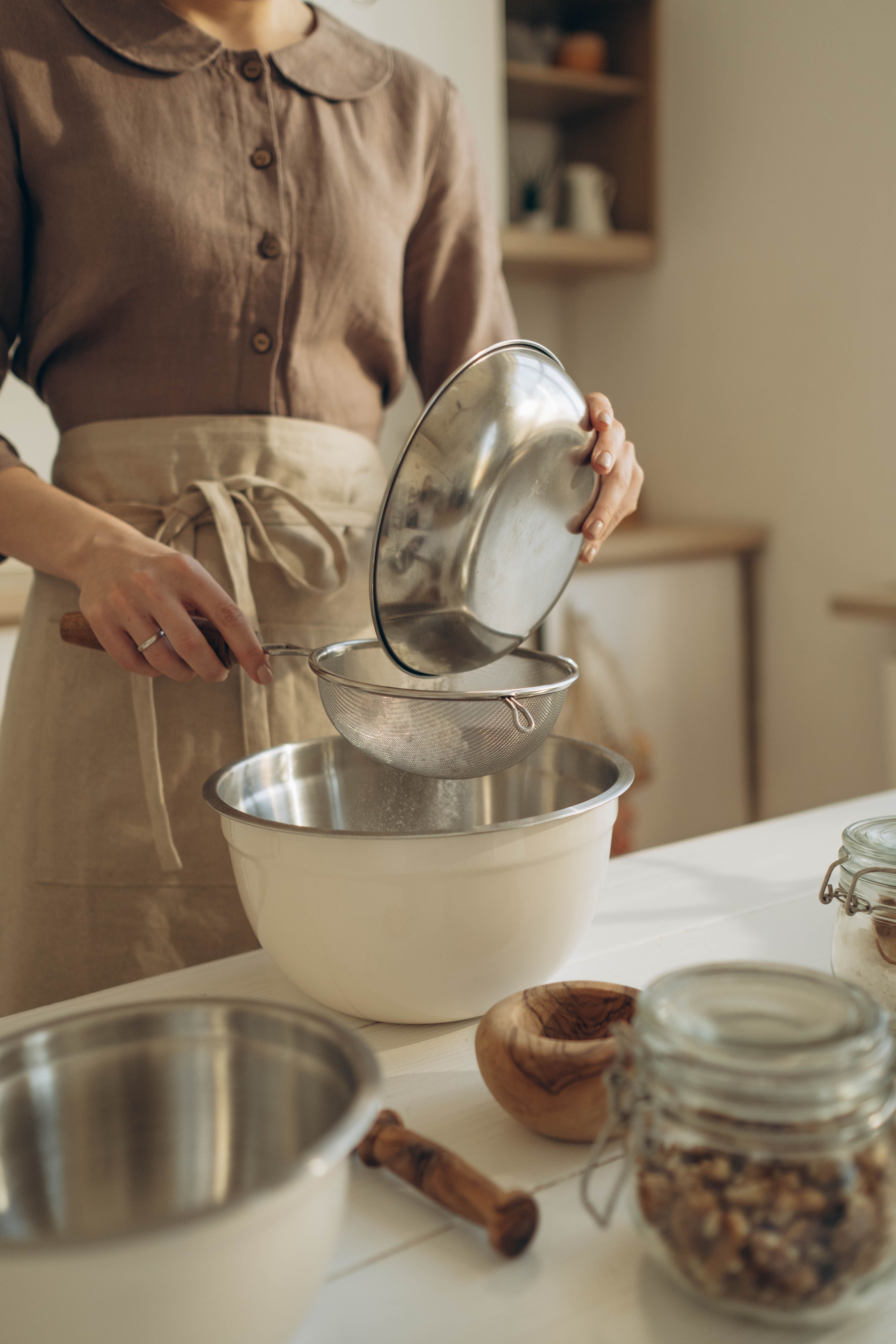 Home cook sifting flour into a mixing bowl